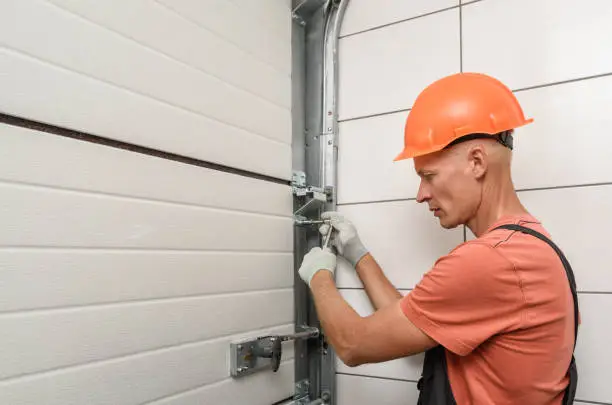 Photo of The worker is installing lift gates in the garage.