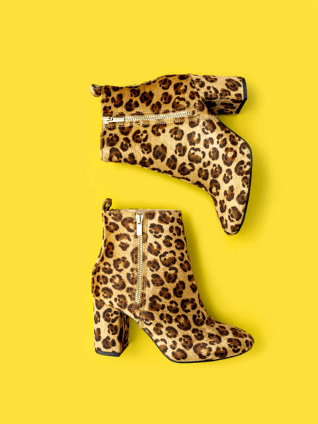 Stylish boots on illuminating yellow background.