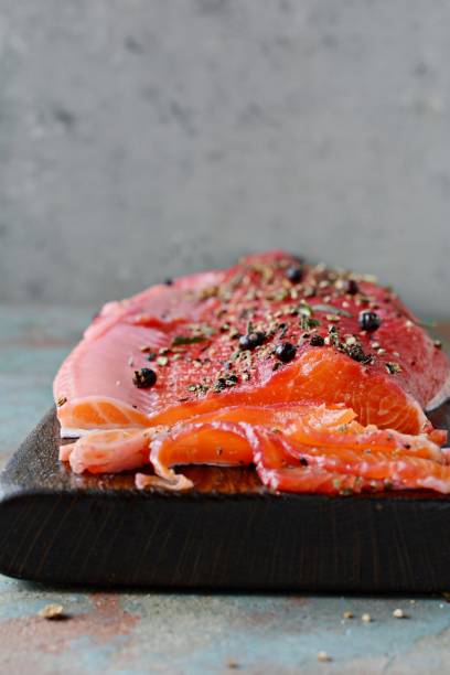 istock Gravlax, scandinavian beet cured spiced salmon on the board, top view, salted red fish 1290765317