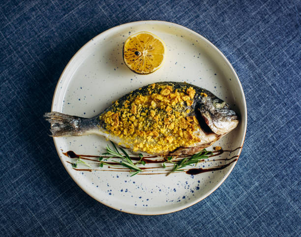 istock Fried fish with fresh herbs and lemon. Top view 1290765982