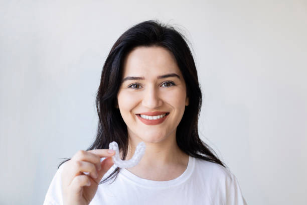 Close-up Of A Woman's Hand Putting Transparent Aligner In Teeth Close-up Of A Woman's Hand Putting Transparent Aligner In Teeth guarding stock pictures, royalty-free photos & images