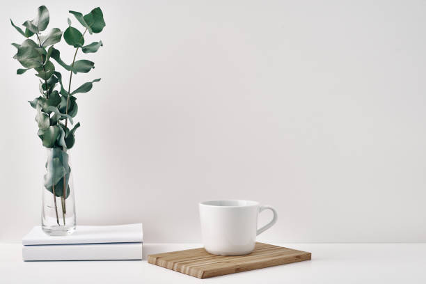 istock A mug, a stack of books, a wooden board and a transparent vase with eucalyptus branches. Eco-friendly materials in interior decor, minimalism. Copy space, mock up 1290775583