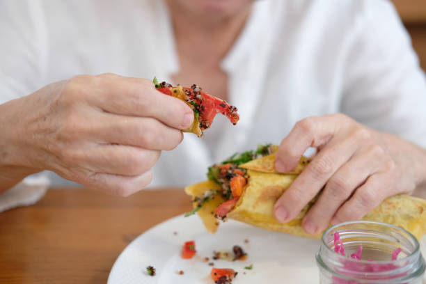 istock hand holding vegan wrap with quinoa, black bean, mango, cashew nut, bell pepper 1290775748