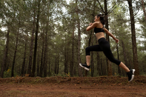 istock Young female athlete jogging in forest. Jogger doing morning physical training. 1290779518