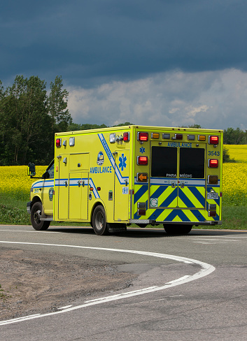 Île d'Orléans, Quebec, Canada - July 18, 2020: Ambulance on roadway responding to emergency call.