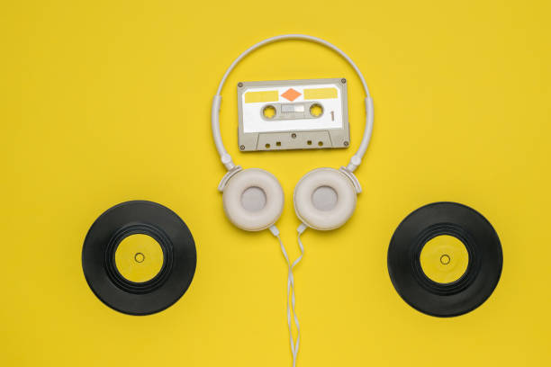 istock Headphones with a cassette and two vinyl discs on a yellow background. 1290792090