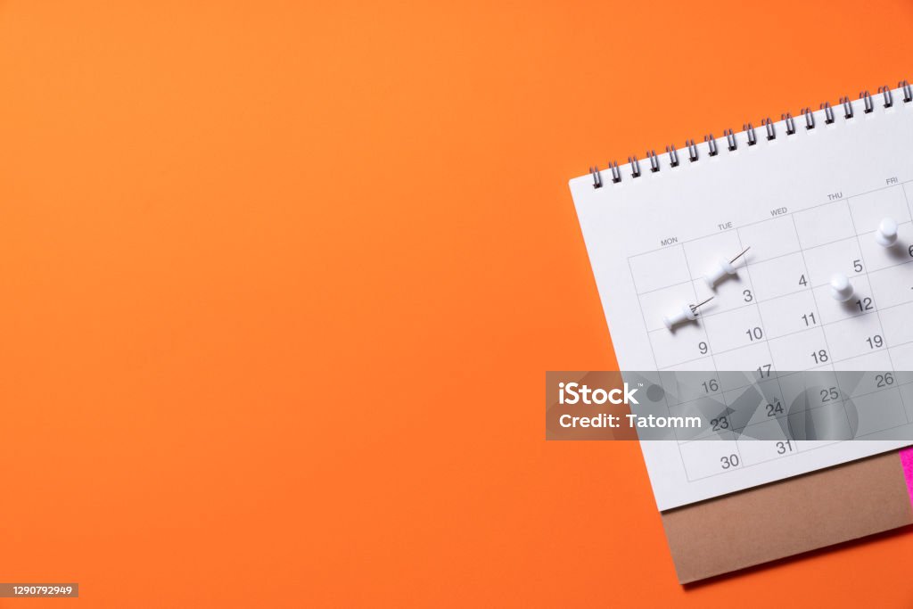 close up of calendar on the orange table background, planning for business meeting or travel planning concept Calendar Stock Photo
