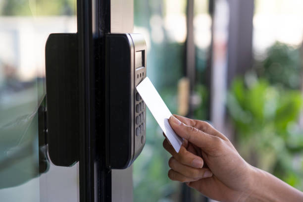 young woman using RFID tag key, fingerprint and access control  to open the door in a office building young woman using RFID tag key, fingerprint and access control  to open the door in a office building radio frequency identification stock pictures, royalty-free photos & images