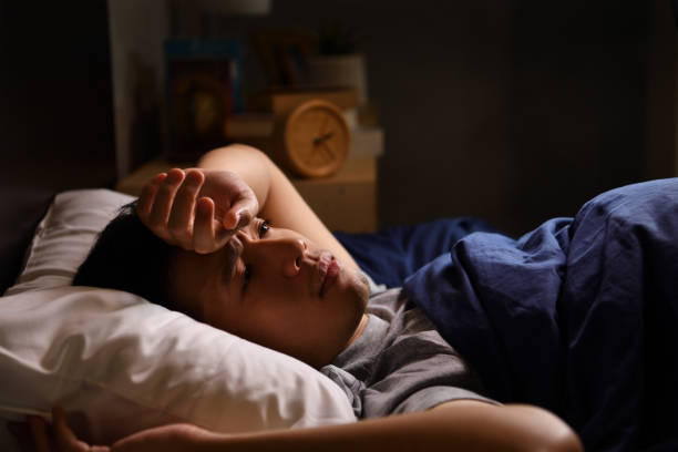 istock A depressed young man suffering from insomnia lying in bed 1290797023