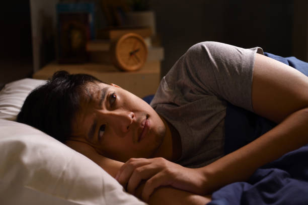 istock A depressed young man suffering from insomnia lying in bed 1290797024