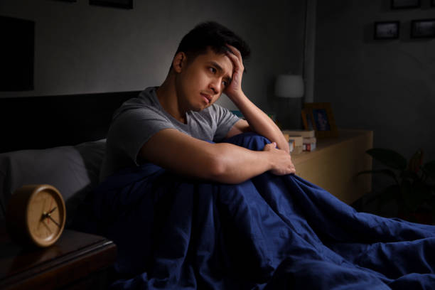 istock A depressed young man suffering from insomnia sitting in bed 1290797025