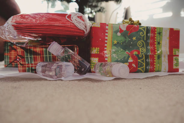 istock Christmas gift wrapped presents with face masks and hand sanitizer bottles 1290802419