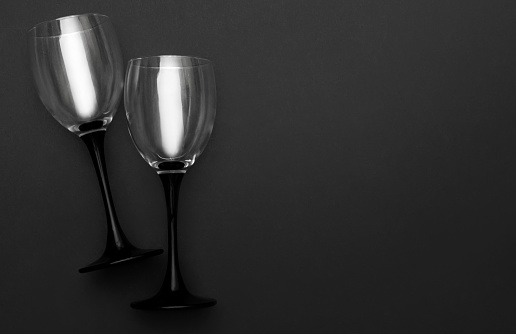 Two wineglasses on black background. Copy space