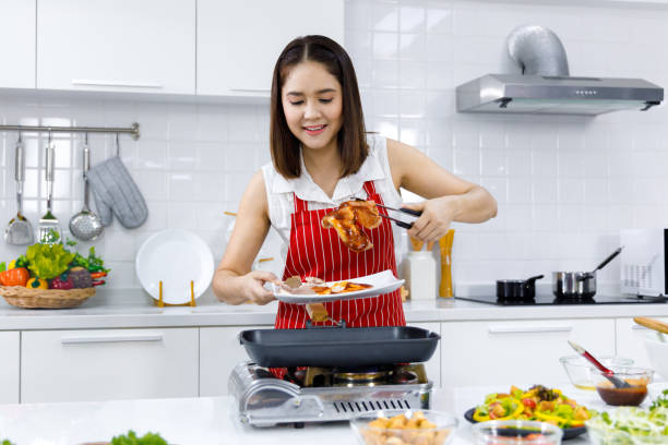 istock Woman cooking steak in kitchen 1290810951