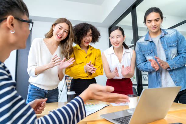istock Multi ethnic group of successful creative business people using a laptop during candid meeting with successful result of profit from laptop 1290811173
