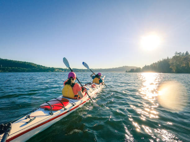 Mother and Daughter Kayaking Together, Suburban Neighborhood in Background stock photo