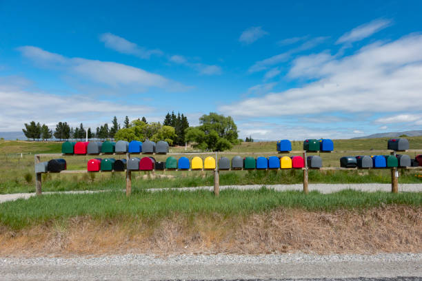 istock Rows if multi-coloured rural lexxterboxes on country road 1290813322