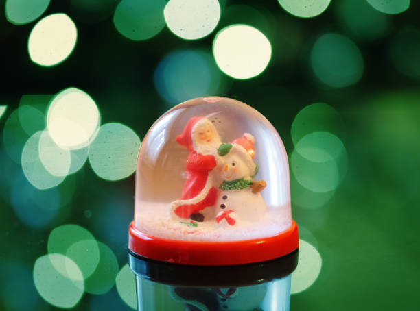 istock Snowing dome with green abstract background at christmas 1290815152