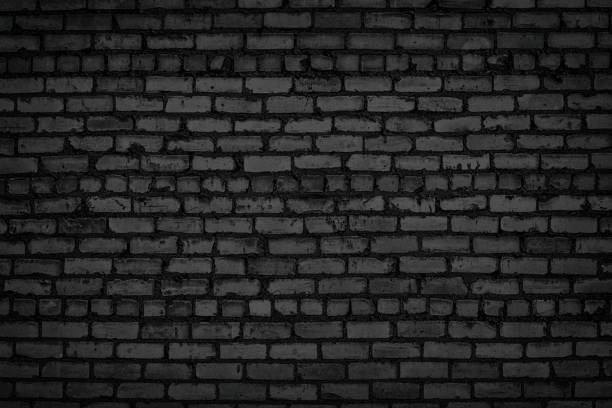 istock Black old brick wall texture. Rough block masonry. Gloomy grunge dark brickwork background 1290816927