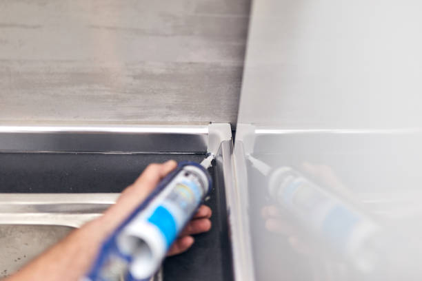 istock Handyman using silicone sealant adhesive bond for fixing household things. 1290817245