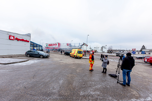 Rezekne, Latvia - December 12, 2020: Rescue manager at a warehouse DEPO in Rezekne, Latvia gives information to local television LRT (Latgale regional television)\n\nAt 02.43 firefighters received a call from Stacijas Street in Rēzekne, Latvia\nAt 10.38, a fire in Rēzekne, where a building with an area of 13,500 square meters is burning, was localized.