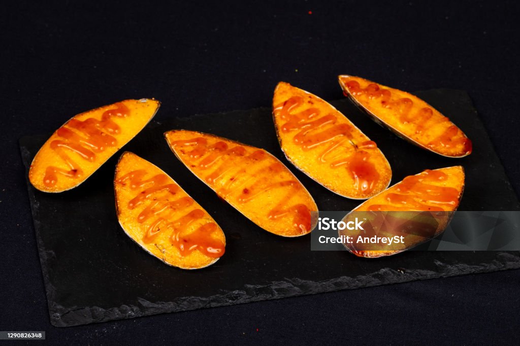 Baked mussels with cheese Baked mussels with cheese and sauce Appetizer Stock Photo