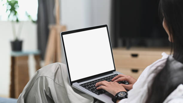 istock A young female relaxing on sofa and using laptop computer mock up blank white screen. 1290827460