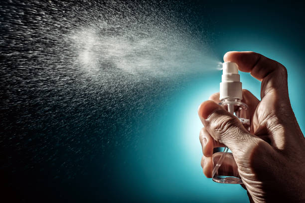istock Pocket sanitizer in hand while spraying disinfectant 1290830643
