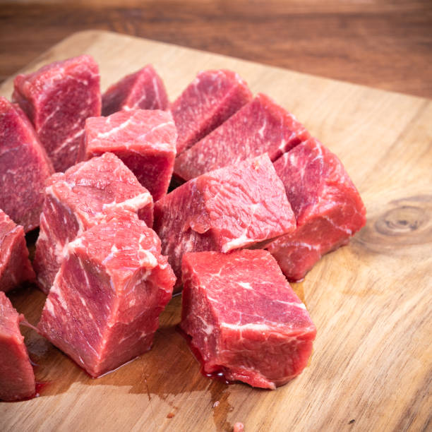 istock Fresh raw beef slices for goulash on wooden kitchen cutting board 1290831074