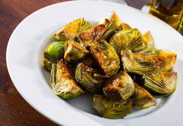 istock Delicious fried artichoke halves on a white plate 1290836680