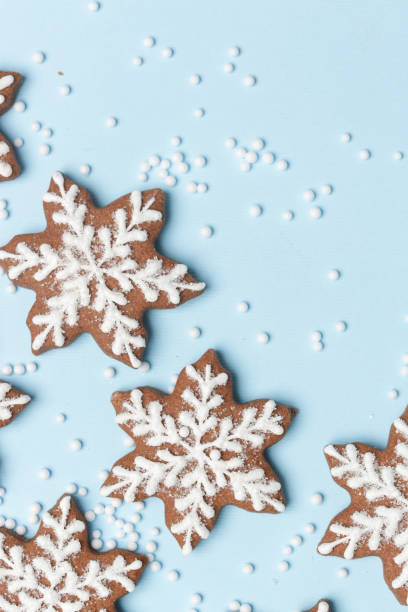 istock Star shaped gingerbread cookies on light blue wintery background. 1290840594