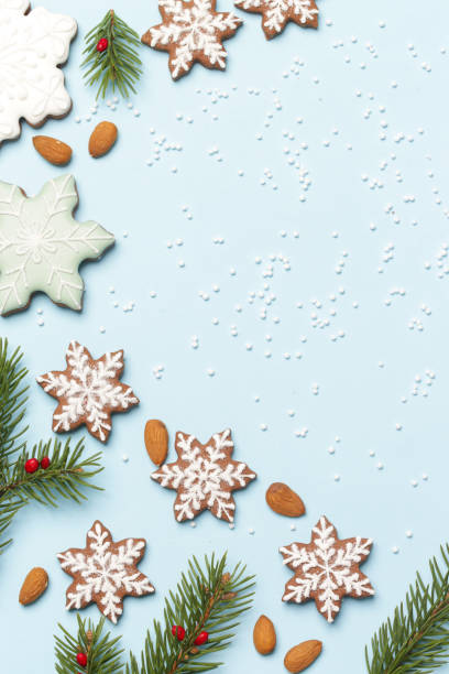 istock Star shaped gingerbread cookies on light blue wintery background. 1290840681