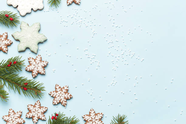 istock Star shaped gingerbread cookies on light blue wintery background. 1290840755