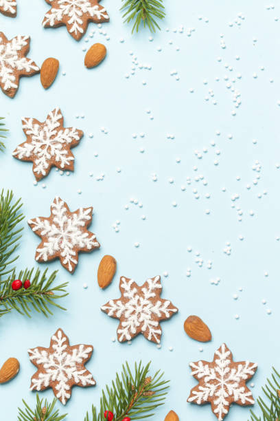 istock Star shaped gingerbread cookies on light blue wintery background. 1290840782