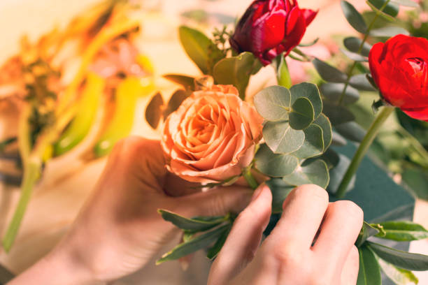 istock Florist at work assembling the bouquet of tulips in a hat box 1290841560