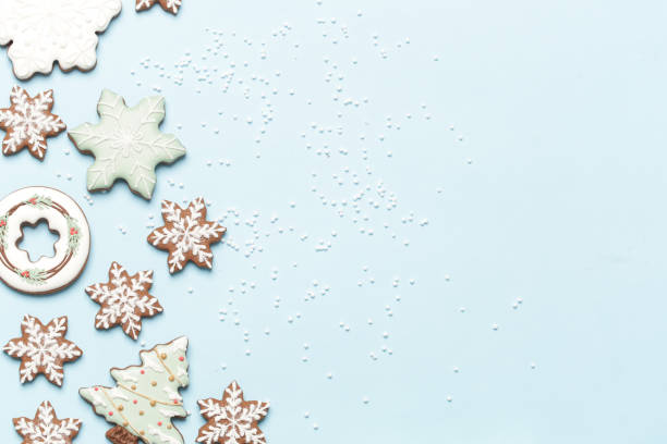 Star shaped gingerbread cookies on light blue wintery background.