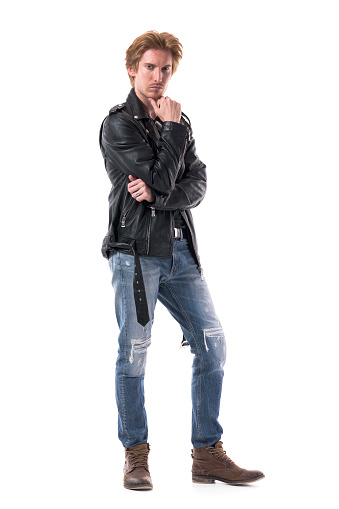 Macho confident redhead stylish rocker male fashion model posing at camera with hand on chin. Full body length isolated on white background.