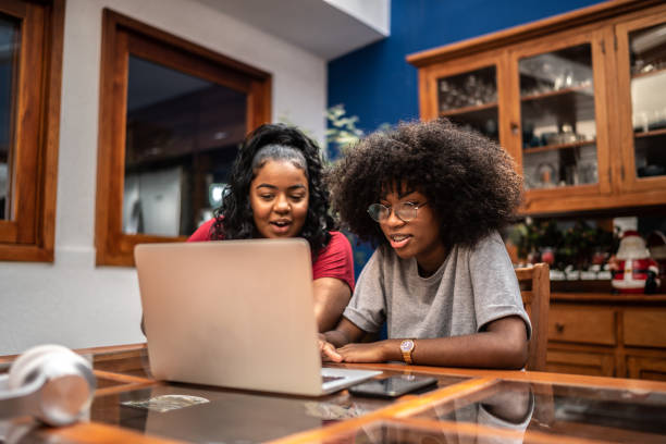 istock Sisters using laptop together at home 1290843058
