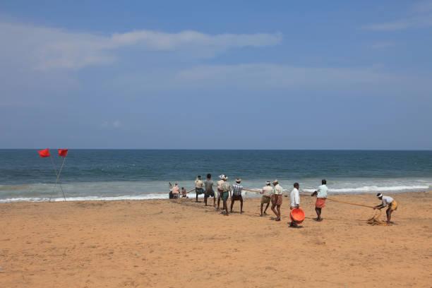 Trivandrum, India - May 14,2017 :Unidentified men pulling the fishing net while they are engaged with dragnet fishing in the Sankhumugham beach in Trivandrum, Kerala, India