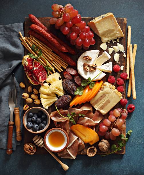 Appetizers platter Appetizers platter with various of cheese, curred meat, sausage, olives, nuts and fruits. Festive family or party snack concept. Overhead view. charcuterie stock pictures, royalty-free photos & images