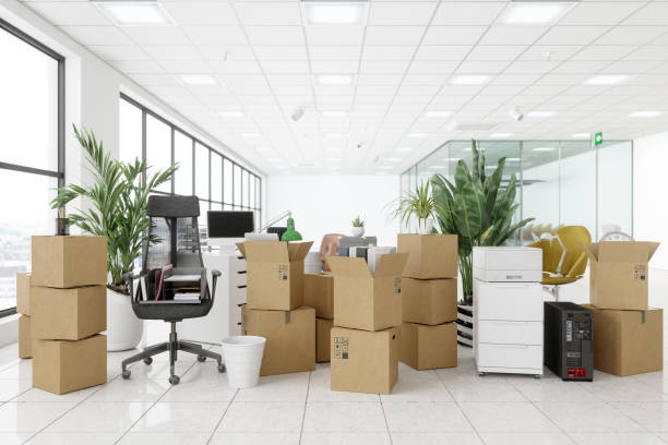istock Moving To New Office With Chairs, Cardboard Boxes, Plants, Computers And Other Office Equipments. 1290846027