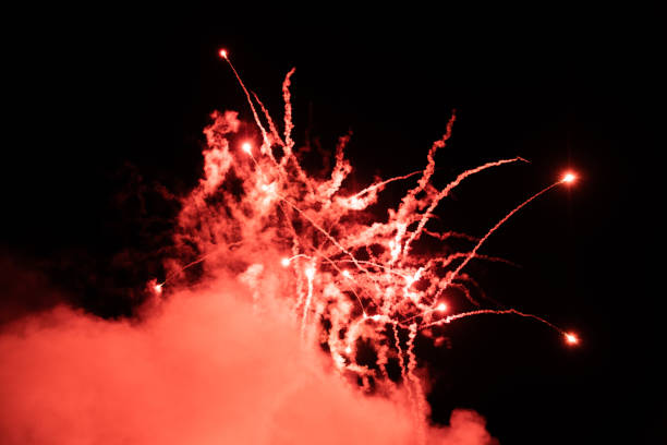 istock Shining fireworks with red smoke. Fireworks emitting sparks at night with dark background. New Years Eve Celebration. Particle Effect, Glowing, Blazing, Twinkling, Glistening. 1290846752