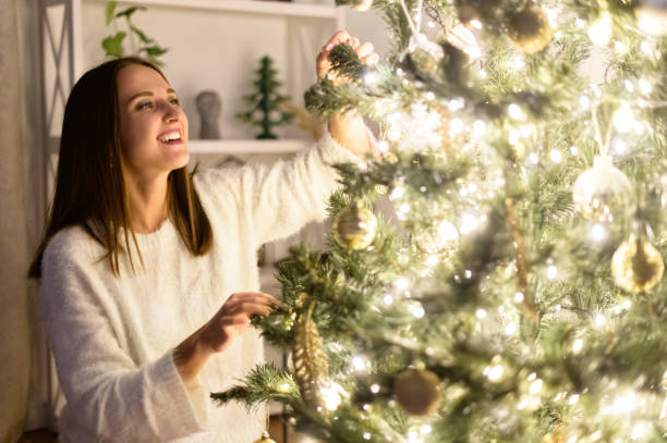 istock A woman hangs Christmas balls on the tree 1290846936