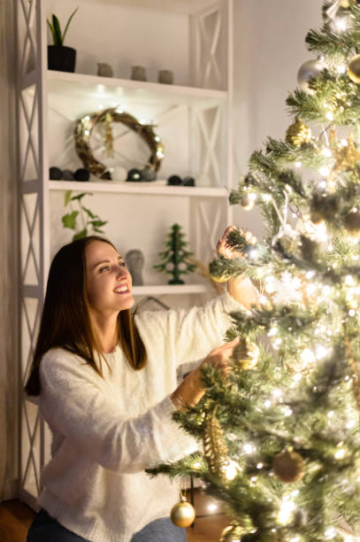 istock A woman hangs Christmas balls on the tree 1290846942