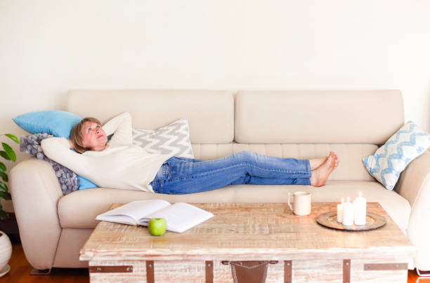 istock Woman resting on sofa at home 1290847042