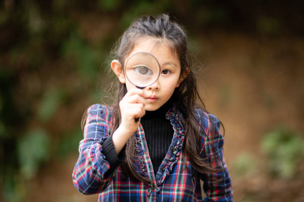 istock Girl playing with a magnifying glass 1290853242