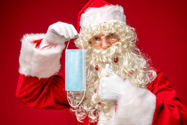 istock Santa Claus holding protective face mask, approving. 1290854074