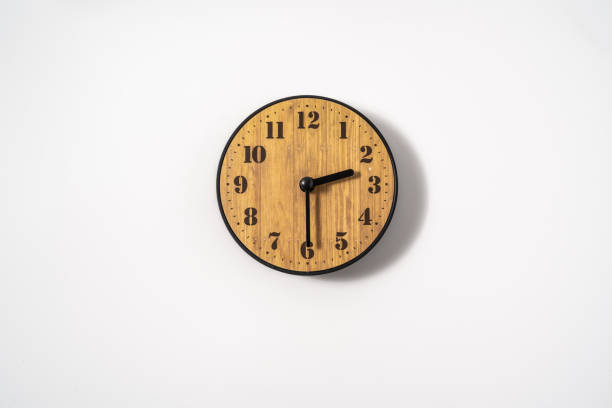 istock wood office wall clock with white dial on white background. wall clock on white background, top view. 1290855894
