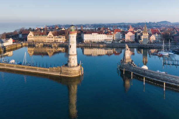 Lindau Bodensee Lake Constance Sunrise Germany Drone view at sunrise towards the Lindau Island Old Town Cityscape under early morning twilight skyscape. Lindau Harbor Bodensee - Lake Constance Entrance with the famous old Lighthouse (left) and Bavarian Lion Sculpture from the year 1856 (right). Lindau Bodensee Waterfront Promenade with Mangturm, Restaurants and Hotels in the Background. Lindau, Bodensee, Bavaria, Germany, Europe lindau lighthouse stock pictures, royalty-free photos & images