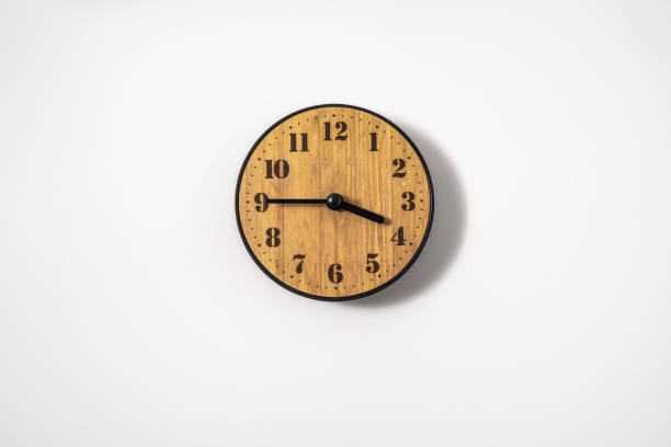 istock wood office wall clock with white dial on white background. wall clock on white background, top view. 1290857564